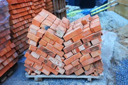 Stack of red clay brick on construction siteの写真素材