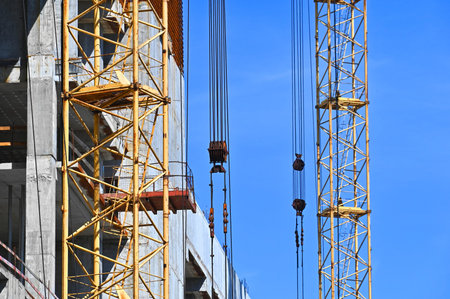Crane and building under construction against blue sky