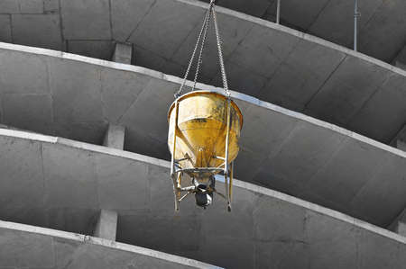 Crane lifting concrete mixer container on construction siteの写真素材