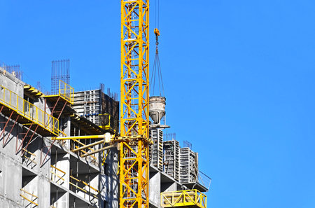 Crane and building under construction against blue sky
