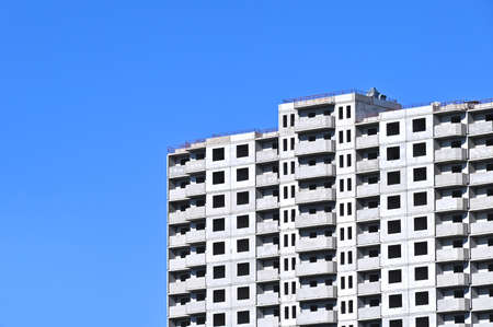 Crane and building under construction against blue skyの写真素材