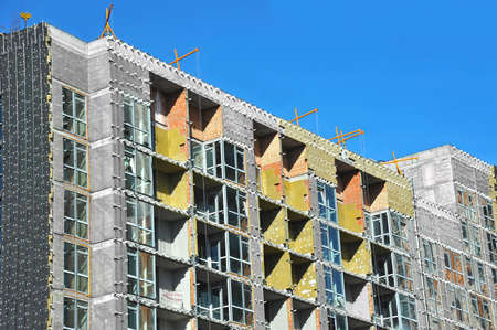 High-rise building construction site work with scaffoldingの写真素材