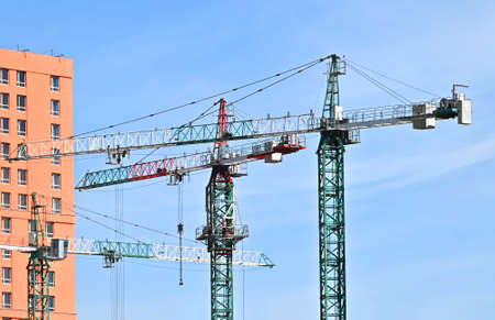 Crane and building under construction against blue skyの写真素材