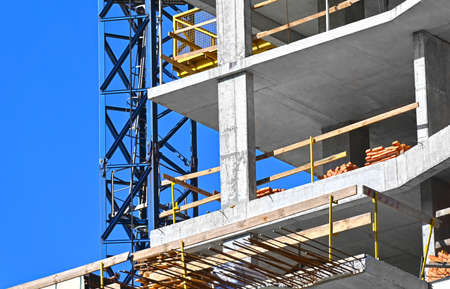 Crane and building under construction against blue skyの写真素材