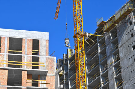 Crane and building under construction against blue sky