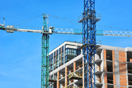 Crane and building under construction against blue sky