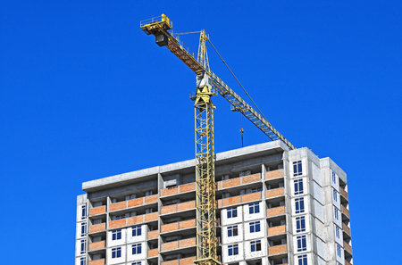 Crane and building under construction against blue sky