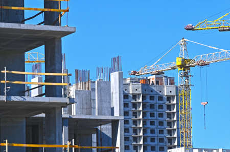 Crane and building under construction against blue skyの写真素材
