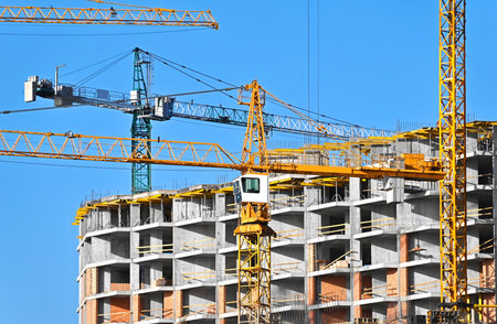 Crane and building under construction against blue sky