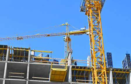 Crane and building under construction against blue sky