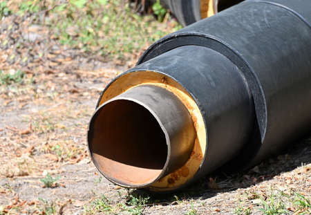 Rusty steel pipe with heat insulation on construction siteの写真素材