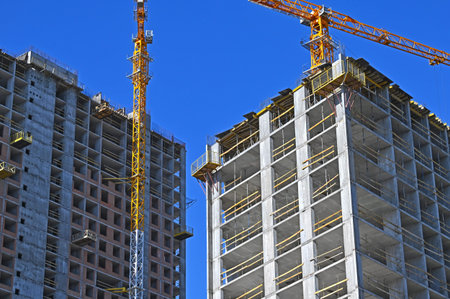 Crane and building under construction against blue sky