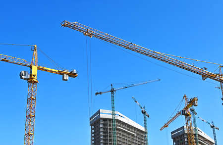 Crane and building under construction against blue skyの写真素材
