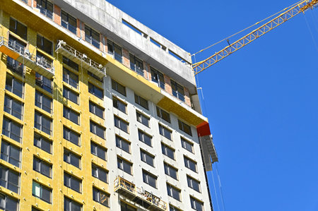Crane and building under construction against blue sky