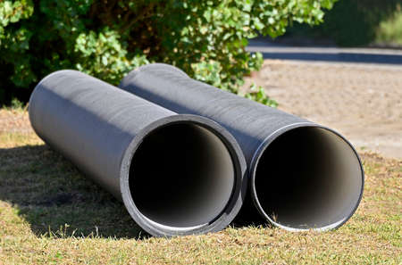 Ceramic sewer pipe stacked on construction siteの写真素材