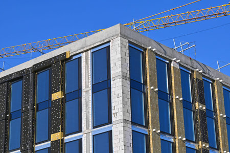 Crane and building under construction against blue sky