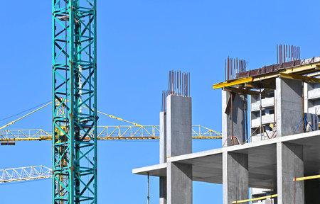 Crane and building under construction against blue sky