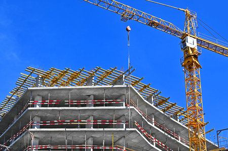 Crane and building under construction against blue sky