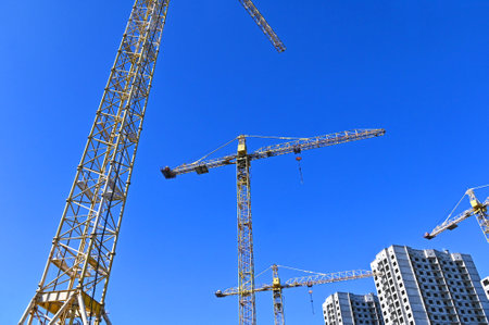 Crane and building under construction against blue skyの写真素材