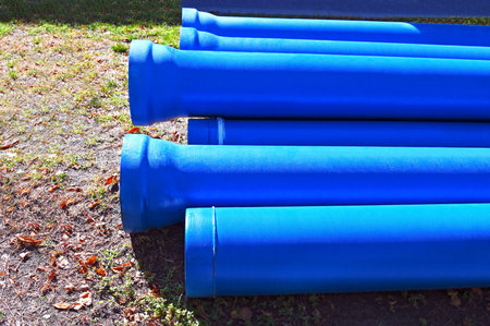 Ceramic sewer pipe stacked on construction siteの写真素材
