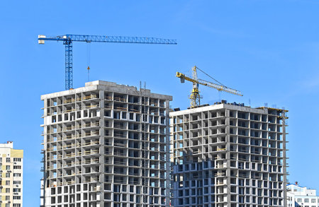 Crane and building under construction against blue sky
