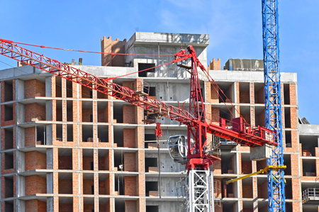 Crane and building under construction against blue sky