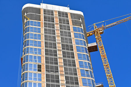 Crane and building under construction against blue sky