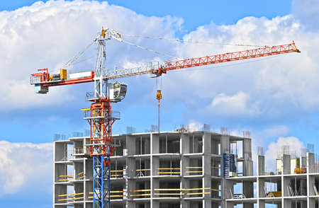 Crane and building under construction against blue sky