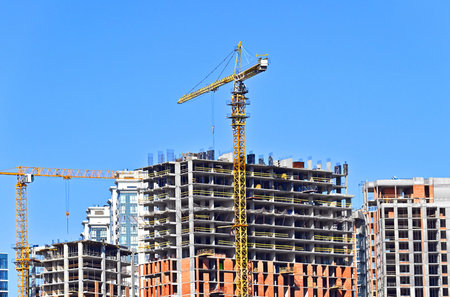 Tower crane and construction against blue sky