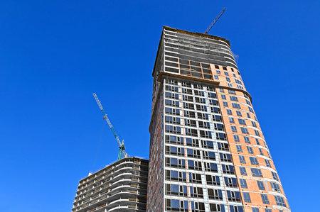 Multistory construction site with crane and blue sky