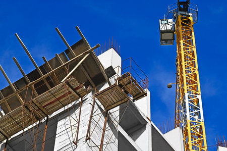 Building crane and construction against blue skyの写真素材