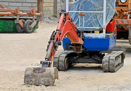 Work of mini excavating machine on building construction site