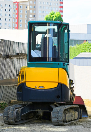 Work of mini excavating machine on building construction site