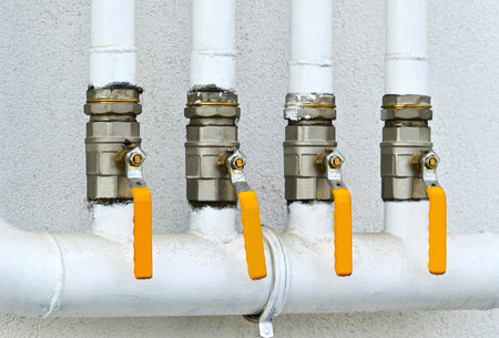 Yellow gas valve on white wall backgroundの写真素材