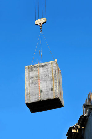 Crane lifting formwork for concrete on construction site