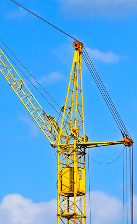 Tall construction tower crane against blue skyの写真素材