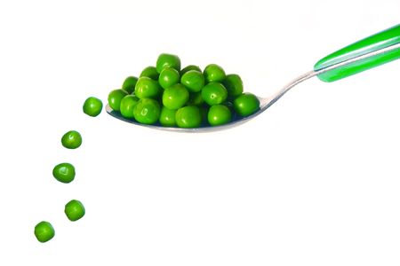 Five peas fall from a silver spoon, isolated on white backgroundの写真素材