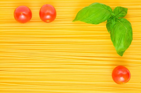 Frame of Spaghetti pasta background with basil and tomatoes; Texture effectの写真素材