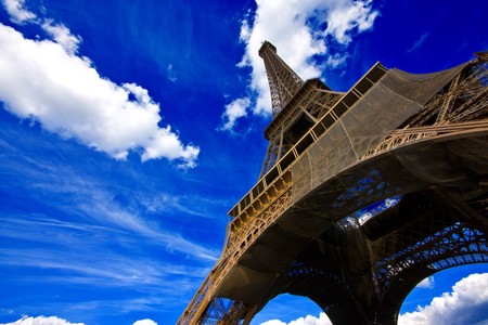 Eiffel tower in Paris, France, against an intense blue sky with white cloudsの写真素材