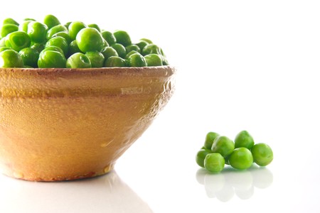 Fresh green peas in a ceramic bowl - isolated on white backgroundの写真素材