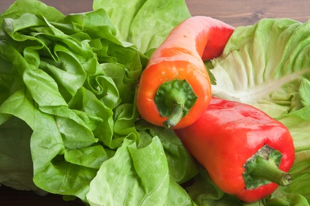 Fresh green lettuce and red peppers on a wooden tableの写真素材