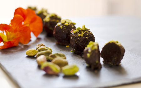 raw food chocolate pralines on a dark plate with decoration