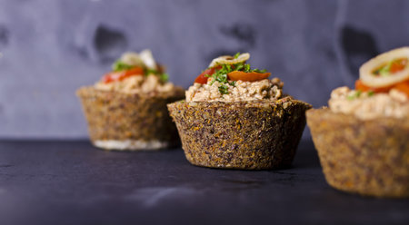 vegan raw food quiche with nut filling and vegetables on topの写真素材