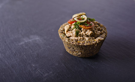 vegan raw food quiche with nut filling and vegetables on topの写真素材