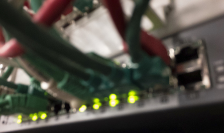 intentionally blurred Patch Panel server rack with different colored cords in the backgroundの写真素材