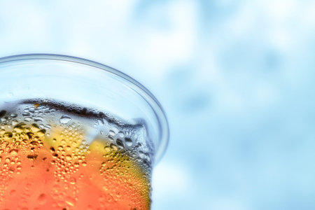 iced tea cool drinks and water vapor around PET plastic glass surface with cloudy blue sky...