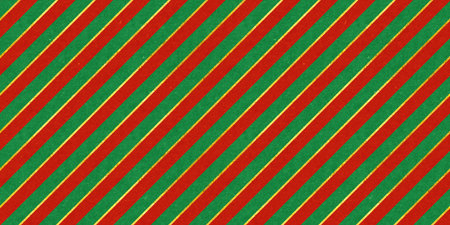 Red and green vintage rough paper textured seamless diagonal candy stripes Christmas pattern with shiny gold foil decoration. Retro xmas card background, winter holiday backdrop or wrapping paper.の写真素材
