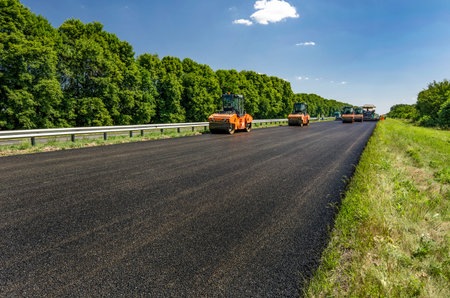 Road roller rolls freshly laid asphalt. Road construction.