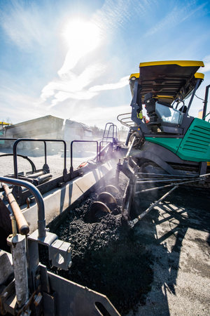 Construction of the road. Asphalt paver in operation.