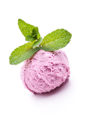 A scoop of wild berry ice cream topped with mint leaves. Real edible ice cream isolated on white background, no artificial ingredients used.の写真素材